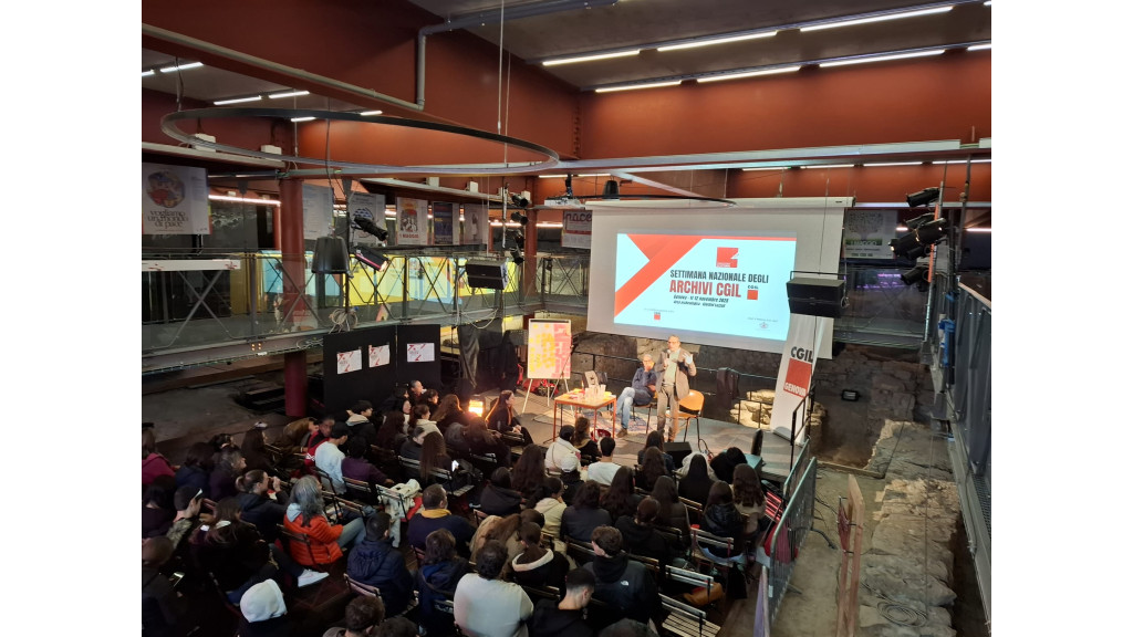 la sala dove si tiene il convegno, con pubblico e palco